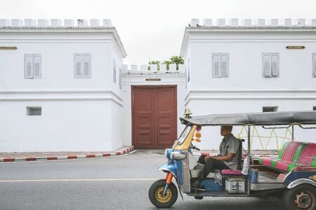 BANGKOK, THAILAND - OCTOBER 15, 2018 : Tuk Tuk taxi driver waiting passengers at Wat Phra Kaew in Bangkok, Thailand.のeditorial素材