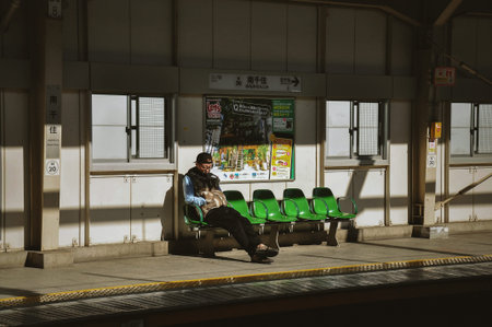 TOKYO, JAPAN - APRIL 06 2014 : Unidentified man waiting for the train at platform at Minami-Senju...