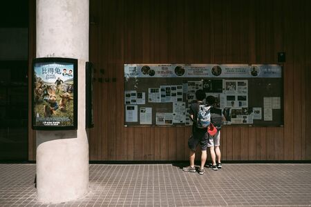 YAU MA TEI, HONG KONG - MARCH 31, 2018 : Unidentified people are reading advertisement at a news board of Broadway Cinematheque in Yau Ma Tei District, Hong Kong.のeditorial素材