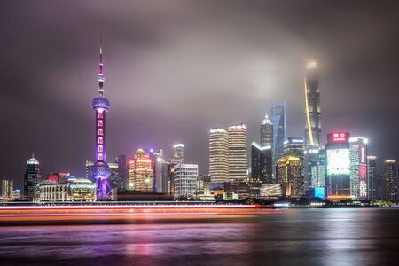 SHANGHAI, CHINA - MAY 18, 2019: Cityscape of Shanghai and Huangpu river at night in Shanghai, China. Pink and blue neon lights.のeditorial素材