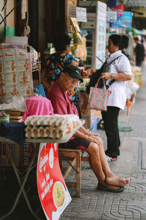 BANGKOK, THAILAND - OCTOBER 15, 2018 : Old man waiting customer on Na Phra Lan Road, Phra Nakhon in Bangkok, Thailand.のeditorial素材