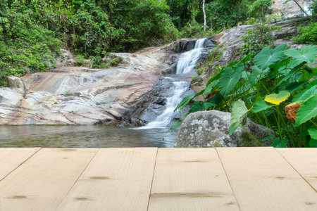 wooden table and waterfall nature backgroundの写真素材