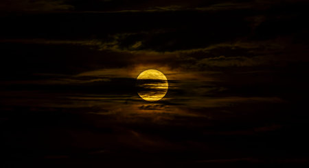 The beautiful full moon surrounded by the silky clouds at night