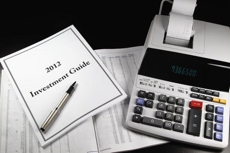 A 2012 investment guide on top of a prospectus with a pen.のeditorial素材