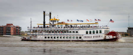 New Orleans, LA - March 27, 2016: The Creole Queen steam boat cruises up the Mississippi river near New Orleans.のeditorial素材
