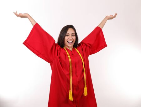 An excited female graduate throws her hands in the air to celebrate.の写真素材