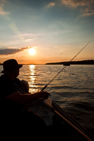 Fisherman on evening who fishing on boatの写真素材