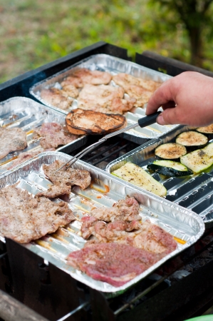 barbecue meat on grill with handの写真素材