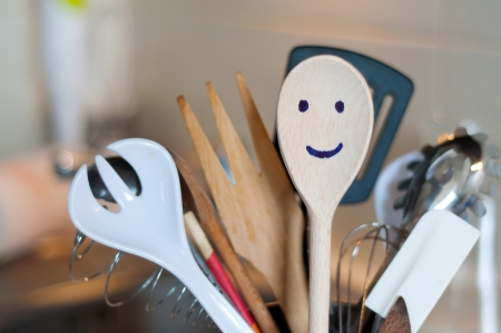 The wooden smiling spoon and kitchen accessories in the kitchenの写真素材