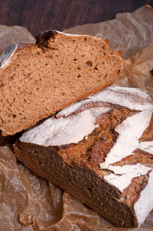 Freshly baked traditional bread on dark wooden table