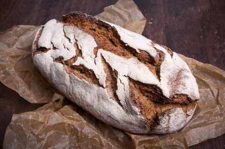 Freshly baked traditional bread on dark wooden tableの写真素材