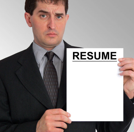 Image of a businessman holding a resume to his left, against a grey gradient background.