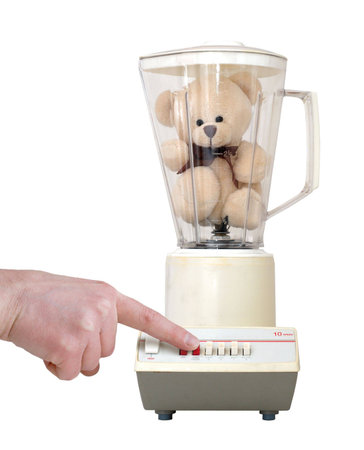Cute little teddy bear in an old-fashioned blender, with a finger pushing the button. Isolated on a white background.の写真素材