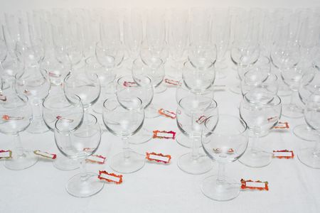 Rows of water glasses with name tags, on a linen tableclothの写真素材