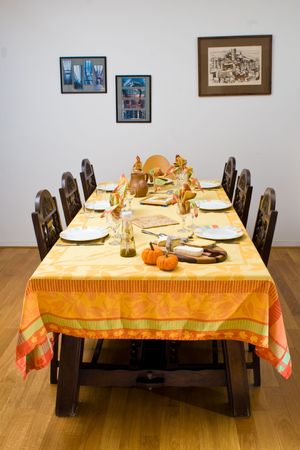 A dinner table set with festive decorations, against a wall with pictures.の写真素材