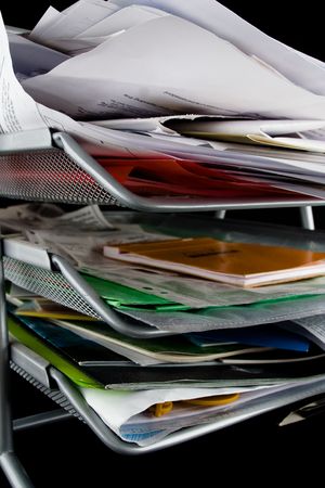 In-basket overflowing with papers,mail and other documents. Isolated on black background.の写真素材