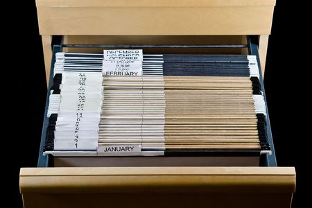 Wooden rolling file cabine t with a drawer opened, showing 43 hanging folders.の写真素材