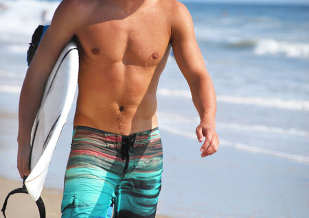 surfer walking the beach