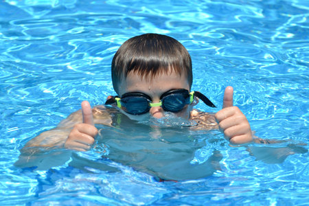 boy in water with thumbs up summer conceptの写真素材