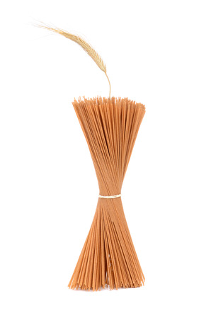 spaghetti noodles and wheat straw isolated on white backgroundの写真素材