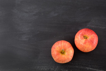 two apples on a chalkboard background with blank spaceの写真素材