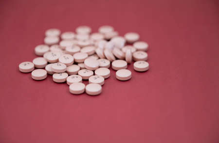 A heap of pills spread over the color table. Group pink tablets. Selective focus. High-quality photoの写真素材