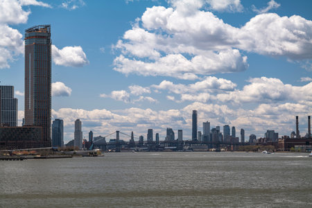 New York City skyscrapers on the river canal have a cloudy and blue sky background. High-quality...