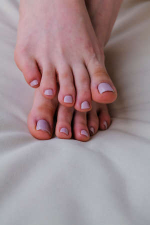Close-up of female feet painted grey nail polish, self made pedicure at home. High-quality photoの写真素材
