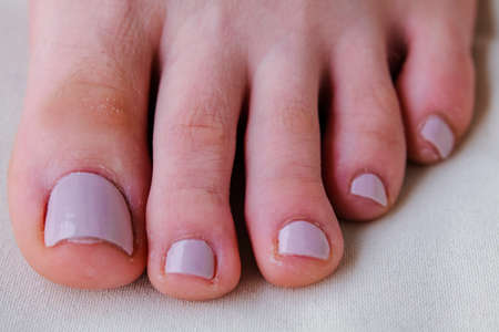 Close-up of female feet painted grey nail polish, self made pedicure at home. High-quality photoの写真素材