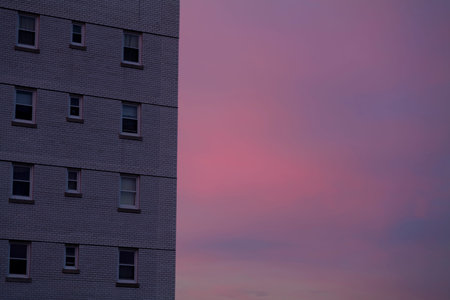 Pink Stratus clouds sunset sky behind the residential building with copy space. City life concept....