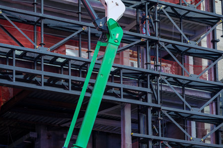 Boom lift stands against scaffolding around building construction. High-quality photoの写真素材