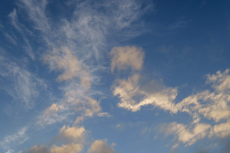 Light wispy cloud formations scattered over vibrant blue sky for clean sky background. High quality...