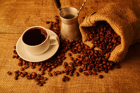 roasted coffee beans, cezve and cup of espresso on sacking backgroundの写真素材