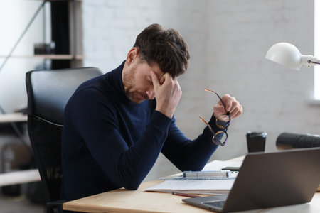 Tired architect working overtime in office. Stressed businessman have financial problems and...