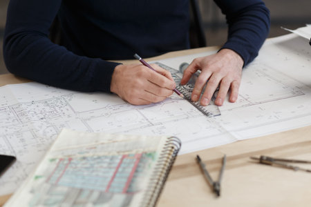Architect working in office with blueprints.Engineer inspect architectural plan, sketching a...