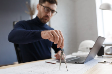 Architect working in office with blueprints.Engineer inspect architectural plan, sketching a...
