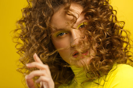 Close up fashion studio portrait of young beautiful women with curly hair.Nice girl with wavy...