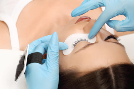 Eyelashes extensions. Fake eyelashes. Eyelash extension procedure.Close up portrait of woman eye...