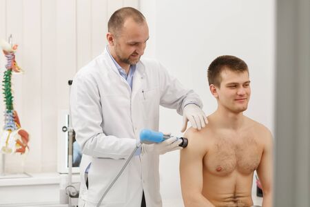 Extracorporeal Shockwave Therapy ESWT.Effective non-surgical treatment.Physical therapy for shoulder with shock waves.Pain relief, normalization and regeneration,stimulation of healing process.の写真素材