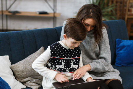 Stay home. Portrait of smiling mother and son using laptop for a online meeting, video call, video...