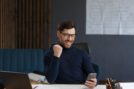 Young man using smartphone and smiling. Happy businessman using mobile phone apps, texting message,...