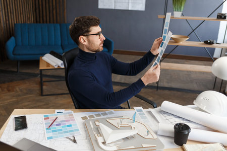 Architect working in office with color palette. Engineer select colors for building using color...