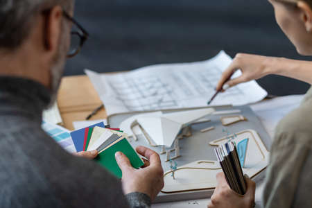 Interior designers team working in office with color palette. Architects select colors for building using color swatches, sketching and planning construction project. Partners discussing at work.の写真素材