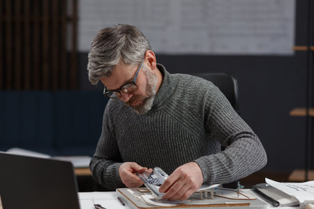 3d architect working in office with building 3D model. Engineer inspect building layout, searching...