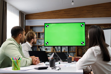 Marketing strategy analysis, stock market trading or corporate teamwork. A team of startups is sitting at a table and talking remotely on a webcam. Green screen. Remote communication, conference.の写真素材