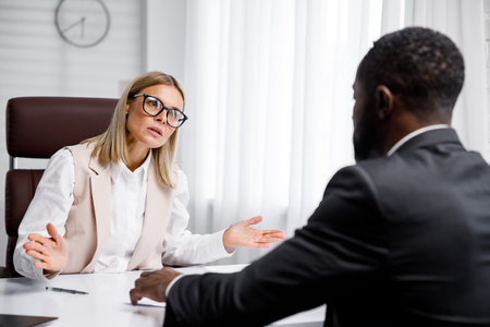 Hiring, interview. Refusal to work due to racism. Business woman refuses to hire an African American. He throws up his hands and looks dismissively.の写真素材