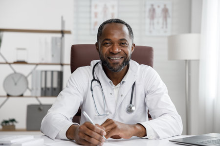 African American male doctor welcomes online patient consultation in laptop. An office providing telemedicine services. online medicine and telemedicine concept.の写真素材