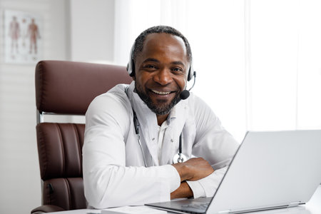 African American male doctor welcomes online patient consultation in laptop. An office providing telemedicine services. online medicine and telemedicine concept.の写真素材