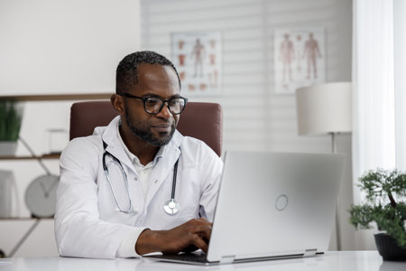 African American male doctor welcomes online patient consultation in laptop. An office providing telemedicine services. online medicine and telemedicine concept.の写真素材