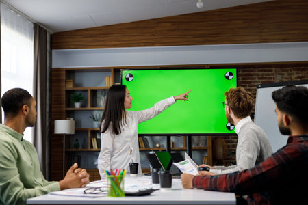 Marketing strategy analysis, stock market trading or corporate teamwork. A team of startups at a table with a large green screen TV. Mixed race business team.の写真素材